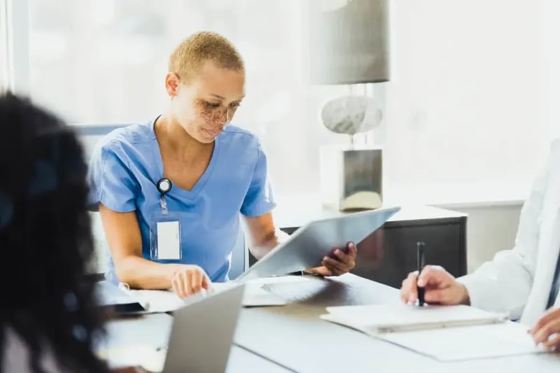 Female therapist reading patient chart